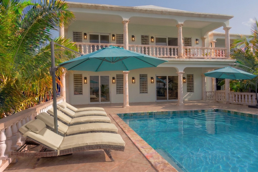 Poolside loungers under a turquoise cantilever umbrella
